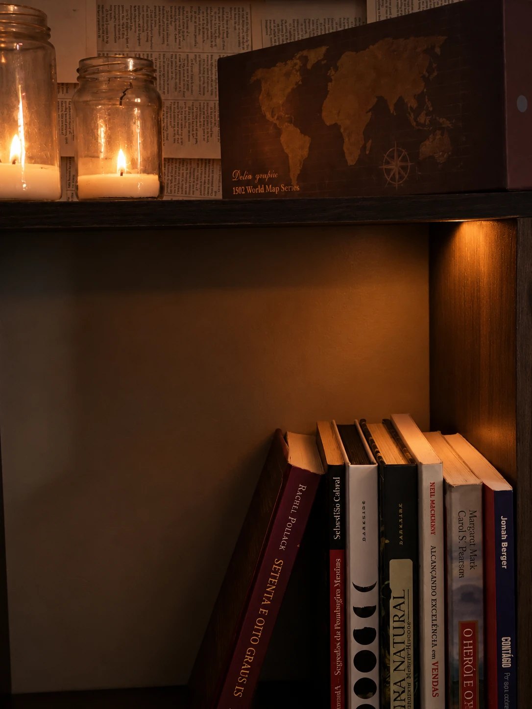 Estante de livros com velas acesas, símbolo de autoridade construída ao longo do tempo